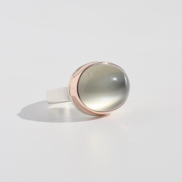 "Jamie Joseph Jewelry has always been about the stones. Working together, Jamie and Jeremy Joseph convey their artistic vision by focusing on bringing light, shape, and an organic framework to some of the most beautiful stones in the world." Sterling Silver & 14k Rose Gold Oval Smooth Green Moonstone "Y" Band Size 7 Handmade in the USA Modern Oval Cabochon Moonstone Ring, Modern Oval Moonstone Ring With Large Stone, Modern Oval Cabochon Opal Ring, Modern Moonstone Ring With Oval Bezel Setting, Oval Modern Moonstone Ring With Bezel Setting, Modern Oval Moonstone Ring With Bezel Setting, Unique Oval Moonstone Ring With Bezel Setting, Timeless Oval Moonstone Ring With Polished Finish, Modern Rings With Large Oval Cabochon Stone