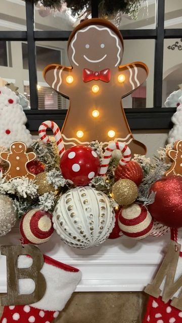 christmas decorations and gingerbread mantelpieces on display in front of a window