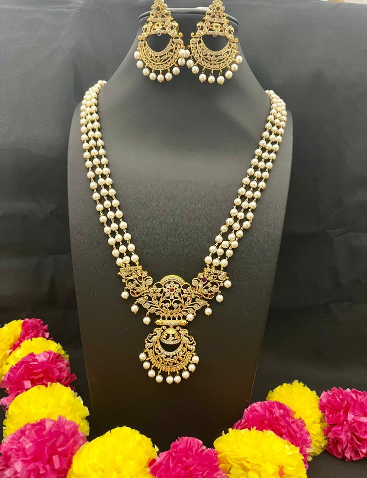 Embrace the cultural opulence of Long Rani Haram Set with Pearls, where each set is a work of art. Whether you're attending weddings, cultural events, celebrating important occasions, or simply seeking to add a meaningful touch to your attire, this necklace promises to adorn you with grace and the timeless charm of traditional jewelry. Elevate your style with cultural flair - order yours now! Here are some of the best ways to care for your artificial jewelry: *Keep it dry away and from moisture. White Round Beads Necklaces For Traditional Ceremonies, White Pearl Necklace With Intricate Design As Gift, White Round Bead Necklaces For Traditional Ceremonies, Gold Chandbali Beaded Necklaces For Wedding, Gold Chandbali Beaded Necklace For Wedding, White Kundan Jewelry For Traditional Ceremonies, Traditional Pearl Chain Necklace For Ceremonies, Bohemian Jewelry Sets With Intricate Design For Wedding, Elegant White Jewelry For Navratri