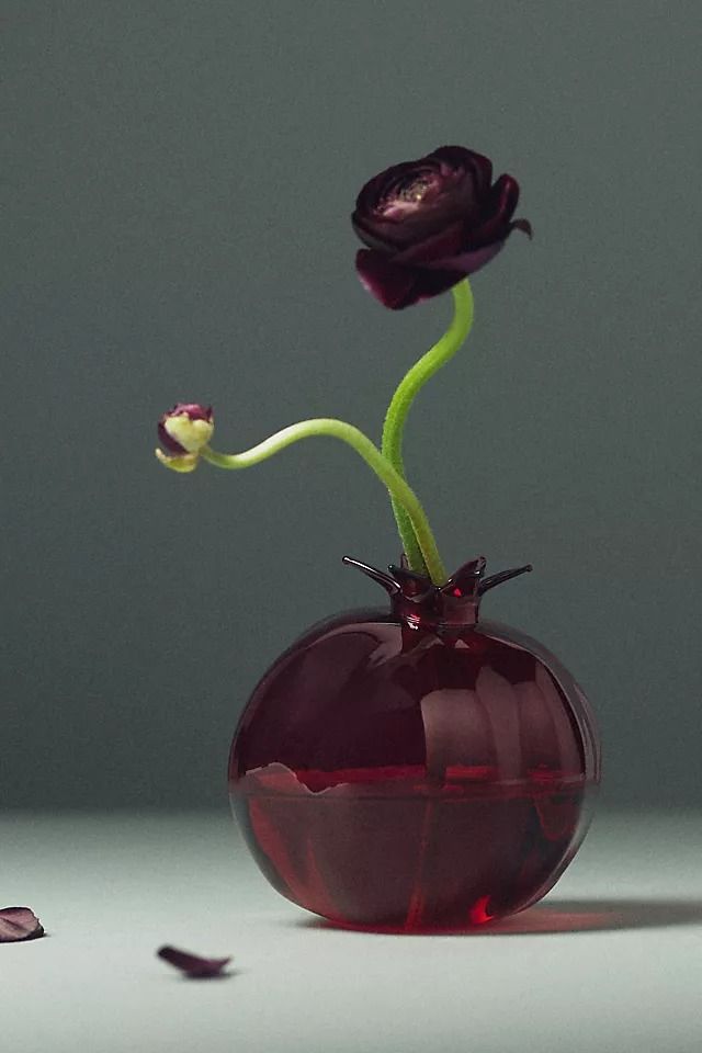 a red vase with two flowers in it