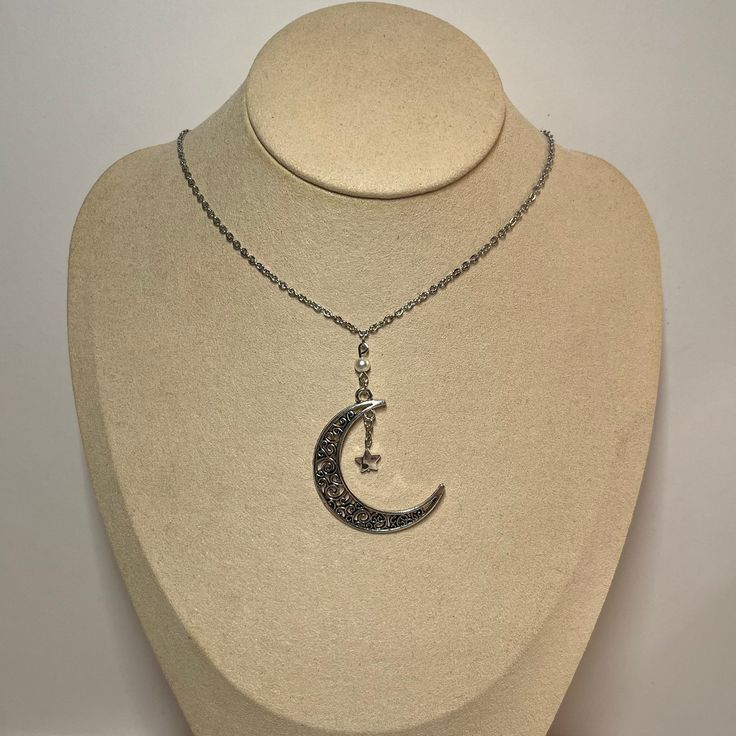 Unique dainty moon necklace with star charm. Made with stainless steel chain. Silver Necklace With Moon Charm And Star Shape, Silver Crescent Charm Necklace With Star, Silver Dangle Charm Necklace With Moon Charm, Dainty Metal Necklace With Moon Charm, Silver Metal Moon Charm Necklaces, Silver Metal Moon Shape Charm Necklaces, Silver Metal Moon Shape Charm Necklace, Crescent Moon Charm Necklace In Stainless Steel, Moon Shaped Stainless Steel Necklace With Moon Charm