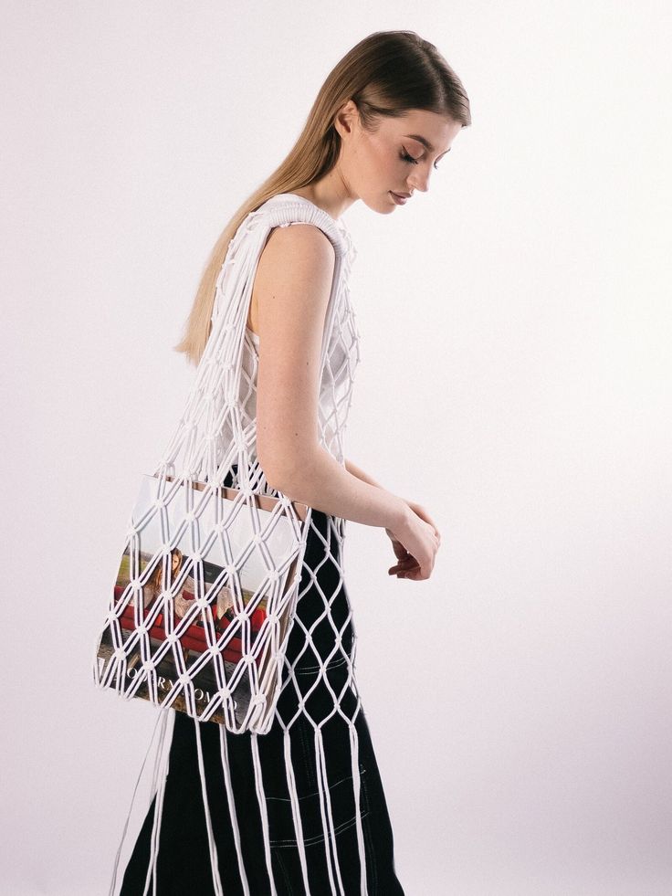 a woman carrying a white bag with strawberries in it