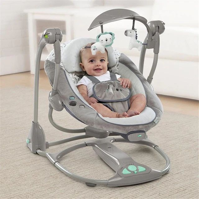 a baby sitting in a swing on the floor