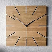 a square wooden clock mounted to the side of a wall with black numbers on it