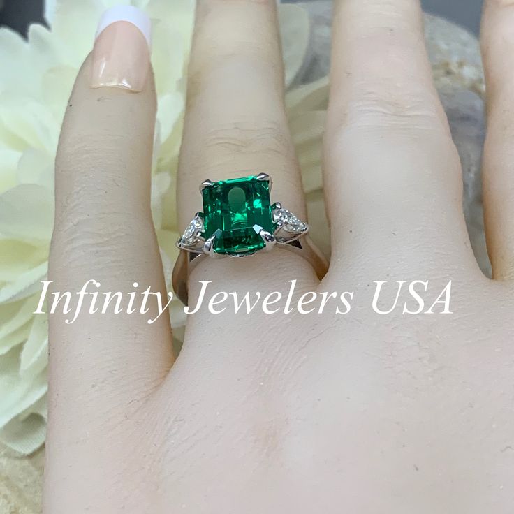 "May Birthstone Ring, Emerald Cut Engagement Ring, Moissanite Engagement Ring, Three Stone Ring, Large Cocktail Ring, 14k White Gold Ring #6722 Emerald is the birthstone of May -Approximate total carat weight: ctw diamond equivalent -Center Stone Size: 10x8mm approx. 3.55ct diamond equivalent -Center Stone Shape: emerald cut -Gem Type: lab created emerald -Stone Clarity: VS2 -Stone Color: lively medium green, eye-clean -Moh's Scale: 8.5 hardness -Accent Stones: 2 pear shapes -Accent Stones Size: Radiant Cut Diamond Ring For May Birthstone, Gia Certified Emerald Ring In 14k White Gold, Diamond Asscher Cut Rings For May Birthstone, Gia Certified Sterling Silver Emerald Ring Fine Jewelry, Gia Certified Emerald Ring In Sterling Silver, Gia Certified Sterling Silver Emerald Ring, Diamond Ring With Prong Setting For May Birthstone, May Birthstone Radiant Cut Solitaire Jewelry, May Birthstone Diamond Ring With Asscher Cut