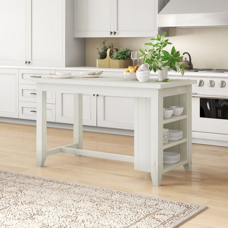 a kitchen with white cabinets and an island in the middle of the room, along with a rug on the floor