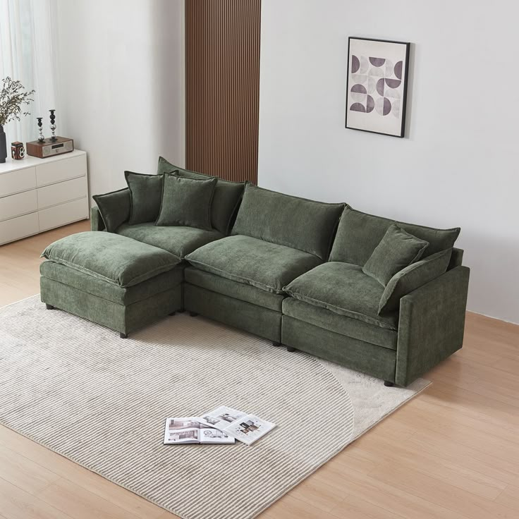 a green couch sitting on top of a wooden floor next to a white rug in a living room