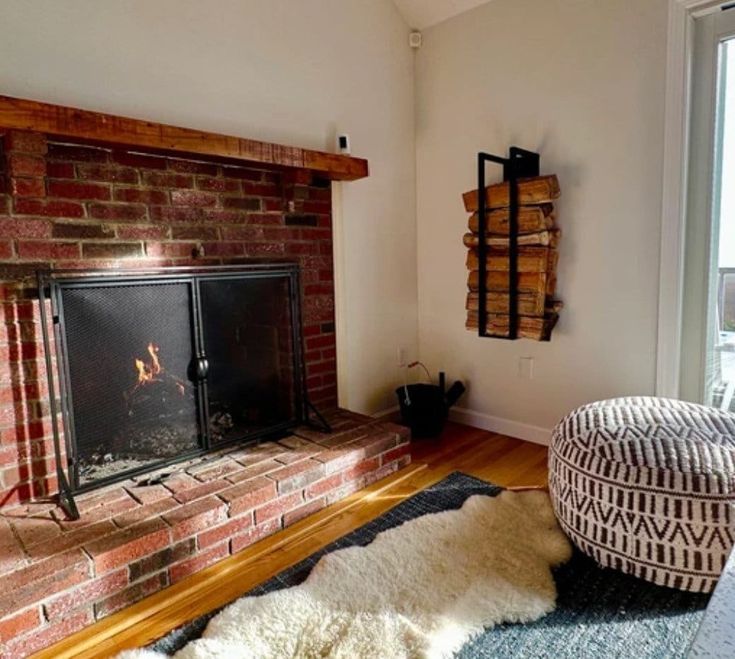 a living room with a fire place in the corner and a rug on the floor