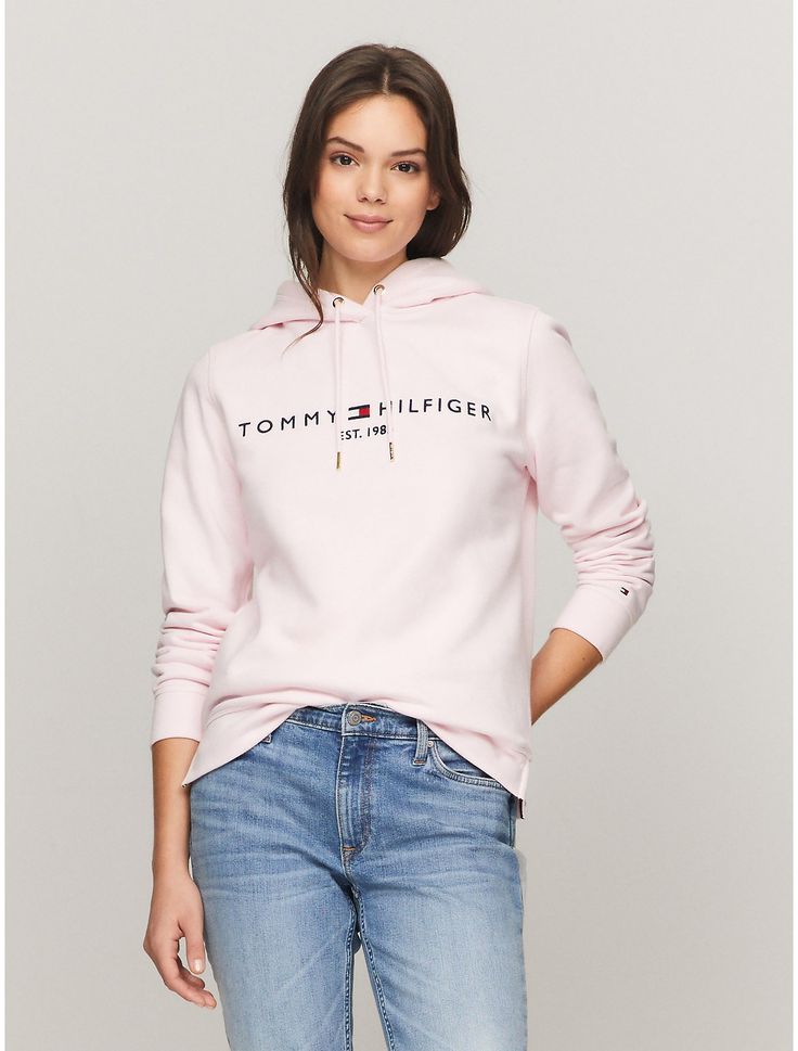 a woman wearing a pink tommy hilfiger hoodie