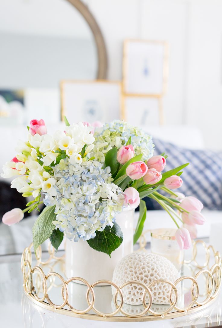 a vase filled with flowers sitting on top of a glass table next to a candle holder