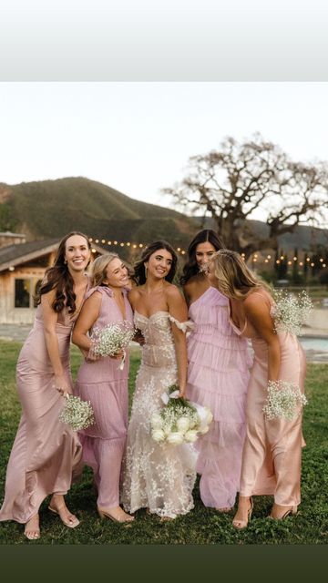 a group of women standing next to each other on top of a lush green field