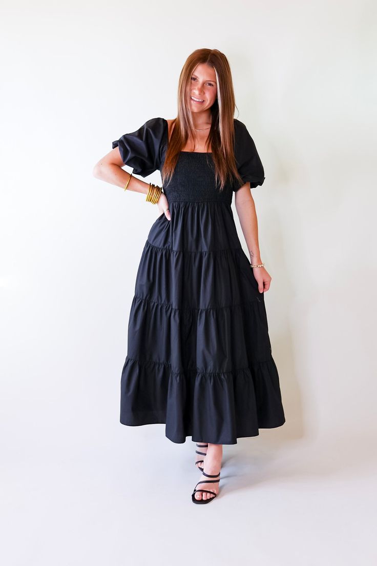 Make a statement in the Santorini Sunshine Short Balloon Sleeve Maxi Dress. This beautiful black dress features a smocked bodice with short balloon sleeves and a tiered skirt for a timeless look. Exuding effortless elegance, this dress is perfect for any special occasion. Arté is wearing a size small. Size Measurements: Small: 2-6 | Bust: 15 inches across the front (smocked, stretches) | Length: 50 inches Medium: 8-10 | Bust: 16 inches across the front (smocked, stretches) | Length: 51 inches La Short Balloon Sleeves, Beautiful Black Dress, Beautiful Black Dresses, Giddy Up Glamour, Sleeve Maxi Dress, Effortless Elegance, Maxi Dress With Sleeves, Tiered Skirt, Balloon Sleeves