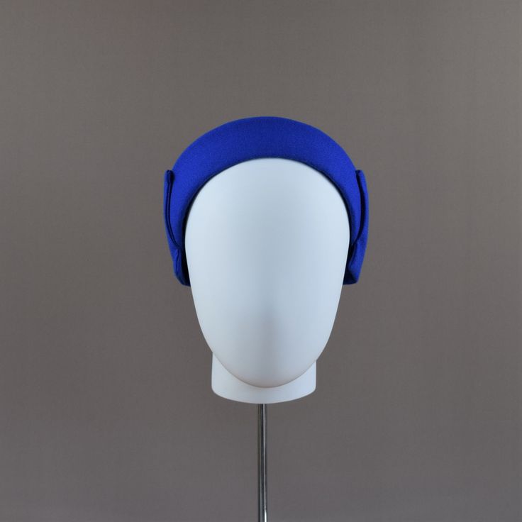 A lovely shaped headband with a ridge running along the centre. Hand blocked and covered in a fine quality lightweight Royal Blue Wool Crepe fabric. Simply decorated with a large crepe bow that sits around the back of the head. A trans-seasonal headpiece suitable for summer or winter wear. This style can be made in other colours (see shade card) however as materials have to be ordered in, there is no return or exchange on this style.  Fabric samples can be ordered here  https://www.etsy.com/uk/l Blue Adjustable Headband Costume Hat, Adjustable Blue Headband Costume Hat, Adjustable Blue Costume Headband, Blue Structured Crown Headpiece For Evening, Blue Adjustable Headpiece With Pinched Crown, Blue Adjustable Headband Fascinator, Adjustable Blue Headband Fascinator, Blue Fitted Headpiece With Structured Crown, Adjustable Blue Headpiece With Pinched Crown