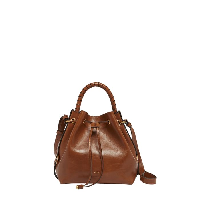 Chloe "Marcie" bucket bag in shiny calfskin  Rolled top handle  Adjustable crossbody strap Can be worn as a top handle or crossbody bag  Drawstring closure  Lining: Leather Approx. 9.4"H x 10.2"W x 5.9"D Made in Italy Luxury Brown Bucket Bag With Top Carry Handle, Cognac Bucket Bag With Handle Drop, Luxury Hobo Crossbody Bag With Top Carry Handle, Brown Leather Bucket Bag With Top Carry Handle, Brown Leather Bucket Bag With Top Handle, Cognac Leather Bag With Round Handle, Cognac Calf Leather Shoulder Bag With Top Carry Handle, Elegant Bucket Satchel With Detachable Handle, Luxury Bucket Hobo Bag For Shopping