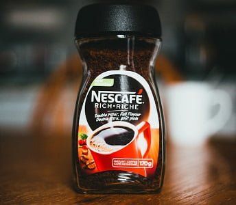 a jar of coffee sitting on top of a wooden table