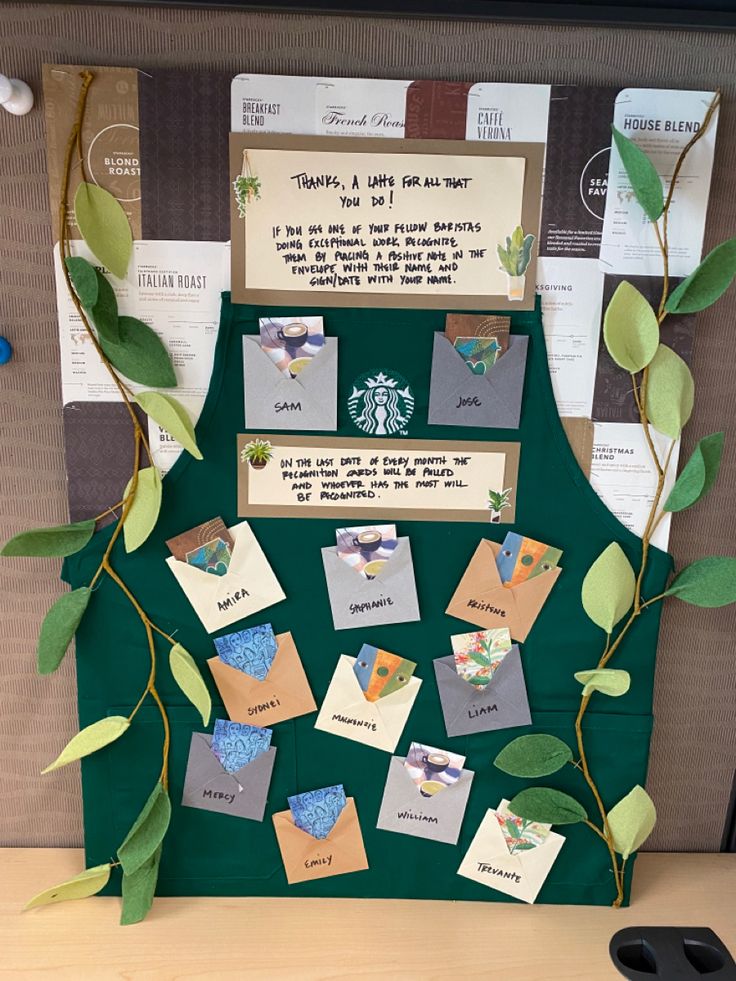 a bulletin board with leaves and cards attached to the back of it, on a desk