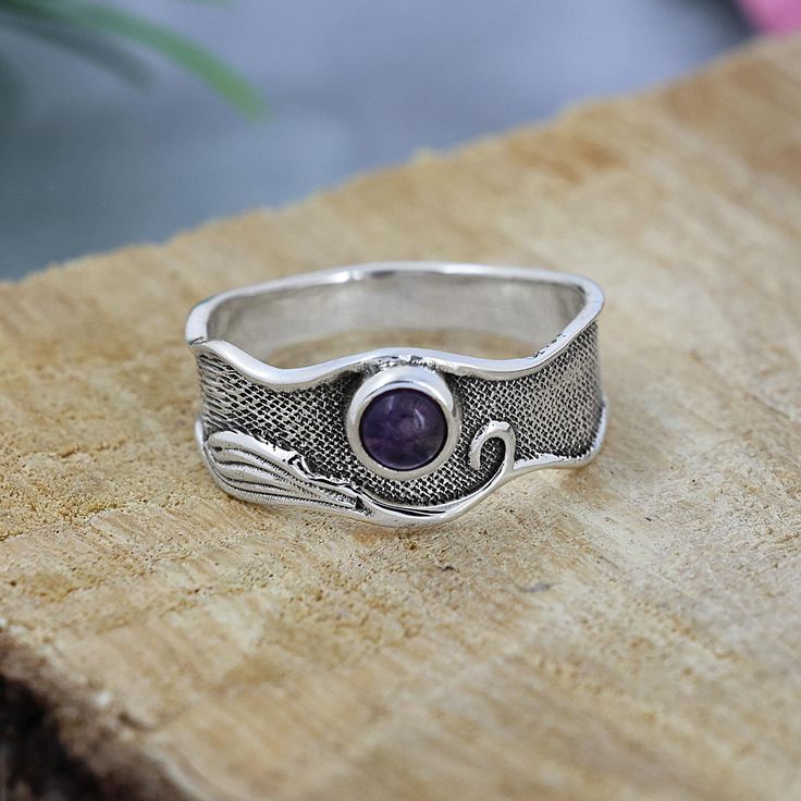 TITLE: -  925 Sterling Silver Wave Band Ring, Natural Amethyst Ring, Textured Band Ring, Designer Ring for Women, Purple Round Gemstone Ring SPECIFICATIONS: - ❖ Metal:  925 Solid sterling silver ❖ Gemstone:  Amethyst   ❖ Gemstone Size: 4mm ❖ Gemstone Shape: Round ❖ Total Weight: 3.2Gram ❖ Gemstone Setting: Bezel    Note: Our use of natural stones may result in slight variations in texture and color in the actual product you receive, but the quality and grade of the stone remain consistent. FEATURES: -  * This striking ring showcases a mesmerizing Labradorite gemstone, set in a detailed sterling silver band. The band features intricate designs, adding a touch of artistry and uniqueness to the piece. The Labradorite, with its enchanting play of colors, brings a sense of mystery and elegance. Sterling Silver Gemstone Rings With Nature-inspired Style, Nature-inspired Sterling Silver Ring Stamped 925, Nature-inspired Sterling Silver Rings With Birthstone, Nature-inspired Sterling Silver Birthstone Rings, Nature-inspired Sterling Silver Ring, Adjustable Stackable Amethyst Ring In Sterling Silver, Nature-inspired Silver Birthstone Rings, Sterling Silver Open Band Ring With Gemstone, Purple Stone Ring