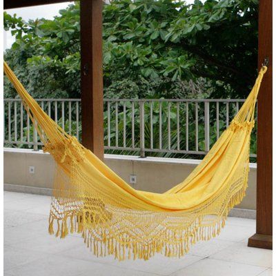 a yellow hammock hanging from a wooden structure