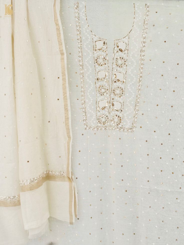 Explore Khinkhwab's exquisite collection featuring the timeless allure of Lucknowi work. Originating from the Mughal era, this ancient embroidery style is among Lucknow's most revered art forms. Each piece, meticulously handcrafted, showcases intricate and delicate white thread, Mukaish work, and pearls, embodying timeless elegance and cultural heritage. Unstitched Slub Silk Suit With Mirror Work, Traditional Slub Silk Sharara With Resham Embroidery, Designer Slub Silk Salwar Kameez With Intricate Embroidery, Gold Embroidered Slub Silk Unstitched Suit, Traditional Sharara With Resham Embroidery, Intricate Embroidered Slub Silk Churidar For Festivals, Intricate Embroidery Slub Silk Churidar For Festivals, Traditional Slub Silk Kurta With Resham Embroidery, Traditional Slub Silk Kurta With Mirror Work