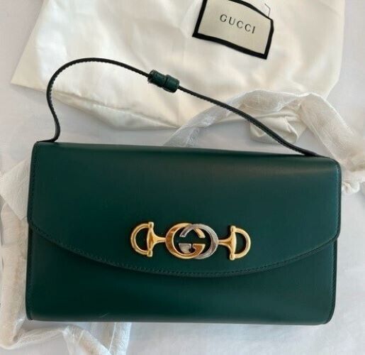 Gucci ZUMI 572375 05J0X 3154 handbag VINTAGE Mini Green Bag Leather  Gucci Zumi Shoulder Bag Mini Green Handbag Designer Bag Leather Italy New Introducing the Gucci Zumi Shoulder Bag Mini in Green—a new addition to the designer handbag collection crafted with exquisite leather in Italy. This compact and stylish accessory showcases the iconic Zumi design, named after the musician Zumi Roscow, adding a touch of modern sophistication to your ensemble. The bag features a single strap for easy carrying and boasts the interlocking silver and gold-toned GG moniker as a prominent detail against its sleek leather body. Embrace the perfect blend of fashion and functionality with the Gucci Zumi Shoulder Bag Mini, an ideal choice for those who appreciate luxury and contemporary style. Product details Gucci Satchel With Branded Hardware, Gucci Top Handle Bag With Branded Hardware, Gucci Top Handle Bag With Logo, Gucci Rectangular Bag With Gold-tone Hardware, Designer Pouch Flap Bag With Gold-tone Hardware, Chic Gucci Bag With Removable Pouch, Gucci Bags With Branded Hardware For Daily Use, Gucci Top Handle Shoulder Bag With Dust Bag, Gucci Tote Bag With Branded Hardware