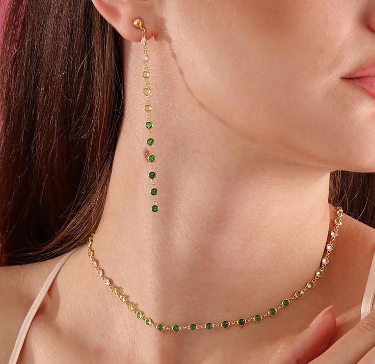 "Emerald Delight Set." This name emphasizes that the green zircon stones are the focal point of the set. Description: The Emerald Delight Set is an elegant jewelry set featuring a delicate necklace and matching long earrings. The green and clear zircon stones set in silver add a captivating sparkle to the set. The necklace's fine and graceful design adds a sophisticated shimmer to the neckline, while the long earrings complete this elegance. Available in gold, silver, and rose gold options, this Green Jewelry Sets As A Gift, Fine Jewelry With Green Clavicle Chain, Green Fine Jewelry Collar Necklace, Green Fine Jewelry With Adjustable Chain, Green Cubic Zirconia Jewelry Sets With Matching Earrings, Emerald Jewelry With Adjustable Green Chain, Green Emerald Jewelry With Adjustable Chain, Green Clavicle Chain Fine Jewelry, Green Cubic Zirconia Clavicle Chain Jewelry