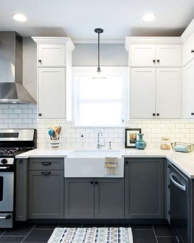 a kitchen with gray cabinets and white counter tops, along with a sink in the center