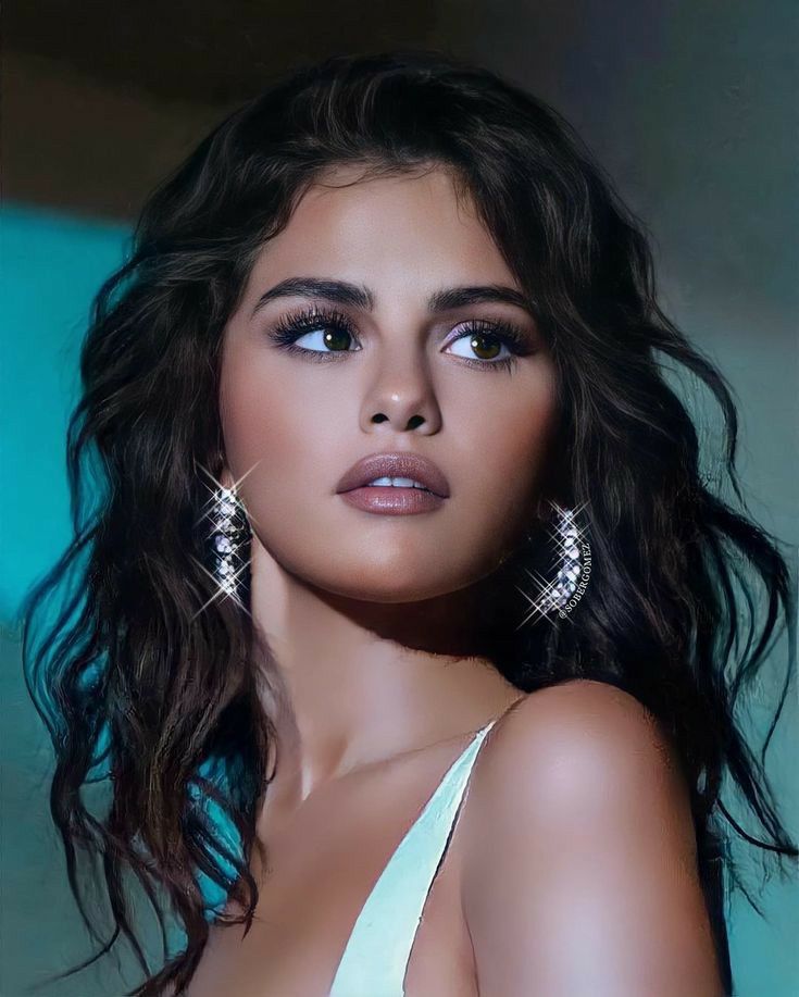 a close up of a person wearing earrings and a white dress with her hair blowing in the wind