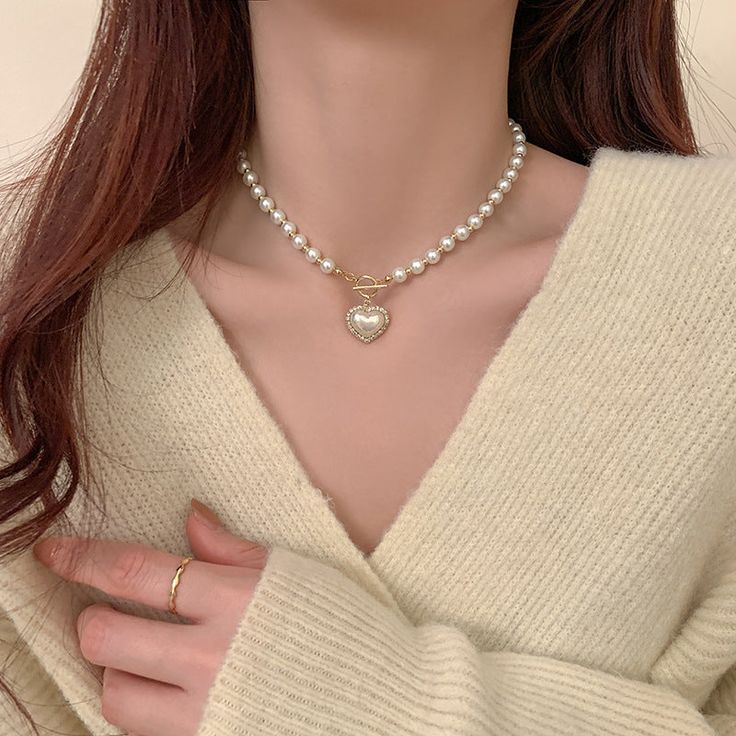 ✦ A must-have accessory for any fashionista, the Mermaid Pearl Beaded hEART cHARM Necklace is sure to add some sparkle and sophistication to your look. With its dainty and special design, this stunning piece will make a statement wherever you go. Get ready to turn heads and make hearts skip a beat when you wear this beautiful necklace! Luxurious, elegant, and timeless! ----------- DESCRIPTIONS ------------ Size (Length): 39.5cm- Color: White, Gold- Materials: Alloy, Mermaid Pearl, Rhinestone- SK Elegant Heart Beads Necklace For Party, Party Beaded Necklaces With Heart Beads, Elegant Party Heart Beads Necklace, White Heart Necklace For Wedding, Trendy Necklaces For Wedding And Valentine's Day, Trendy Wedding Necklaces For Valentine's Day, White Pearl Chain Heart Necklace, Heart-shaped Beaded Clavicle Chain Necklace For Gift, Heart-shaped Beaded Clavicle Necklace As Gift