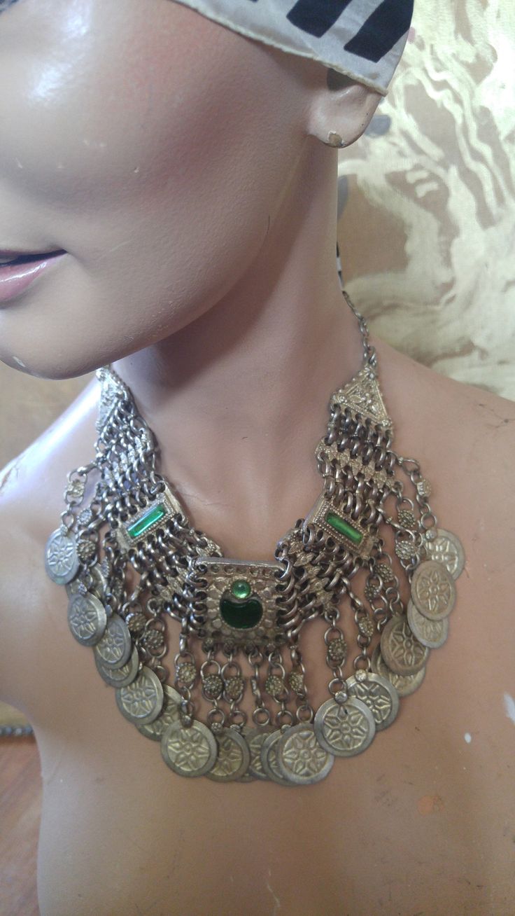 "80's silver tone Afghan Kuchi faux coin choker. There are green glass beads in the centre piece and at the ends, chain clasp at the back. Length in total 23\", at shortest 17 1/2\", width 1 1/2\"" Vintage Metal Necklace With Coin Pendant, Vintage Metal Coin Necklace, Handmade, Vintage Handmade Metal Coin Necklace, Vintage Metal Medallion Necklace With Coin Pendant, Vintage Silver Chain Necklace For Festivals, Vintage Coin Shaped Medallion Necklace, Vintage Silver Coin Necklace For Festivals, Vintage Metal Medallion Coin Necklace, Green Metal Necklaces For Festivals