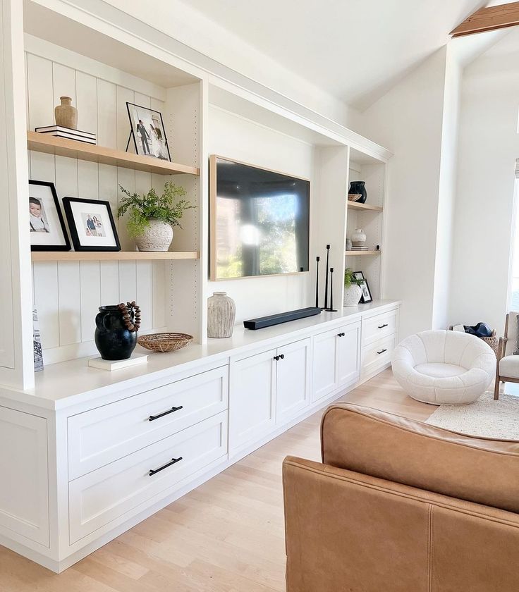 a living room filled with furniture and a flat screen tv on top of a wall