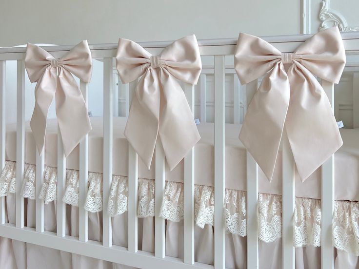 the crib is adorned with pink bows and laces for baby's bedding