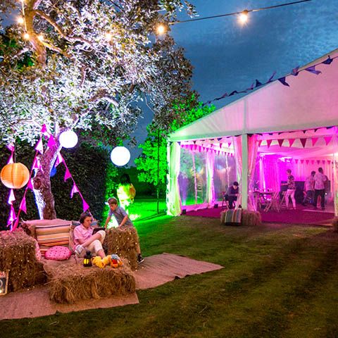 an outdoor event with hay bales and lights