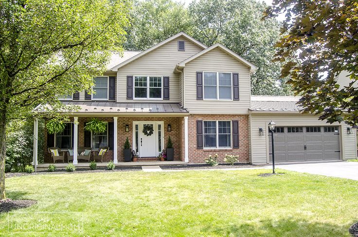 a large house with two garages in the front yard and trees on both sides