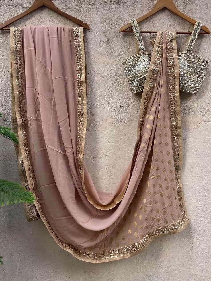 A two-piece nude gold saree set from the Priti Sahni collection. This gorgeous nude gold saree in georgette fabric is embellished with dull gold sequin, and zari border. The saree pallu is enhanced with gold butti work. The outfit is completed with a hand embroidered bustier with a mirror-sequins tassel tie-up at the back. National Institute Of Design, Gold Sequin, Georgette Fabric, Nude Color, Indian Ethnic Wear, Georgette Sarees, Embroidered Blouse, Neck Designs, Wedding Outfit