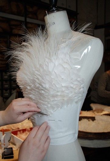 a mannequin being made with white feathers