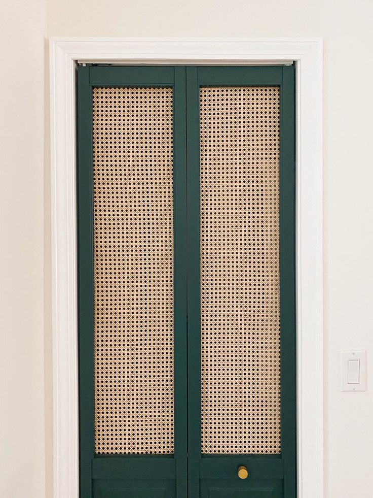 an open green door in the corner of a room with white walls and flooring