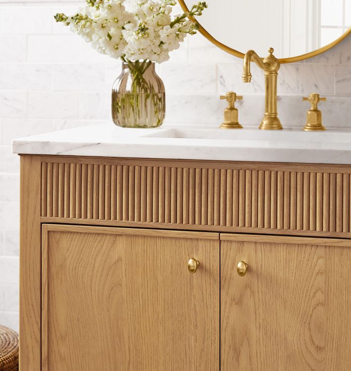 a bathroom vanity with flowers in a vase on it