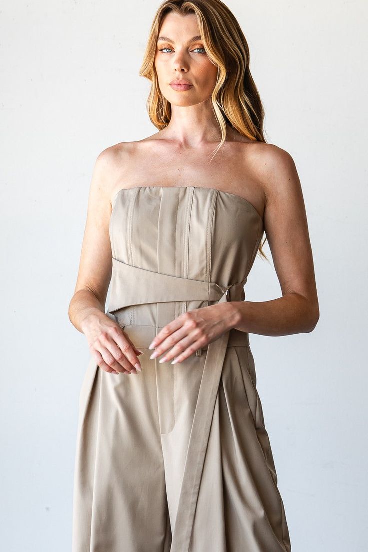 Taupe Pinnacle Bandeau Jumpsuit Step into sophistication with the Taupe Pinnacle Bandeau Jumpsuit, an elegant piece that combines modern style with timeless grace. Ideal for work, formal events, or a chic evening out, this jumpsuit features a flattering bandeau top and wide-leg design that offers both comfort and class. Strapless Bandeau Top: Showcases a sleek and streamlined look with a flattering tube top. Full-Length: Provides an elongated silhouette with wide legs, ideal for a sophisticated Chic Fitted Pantsuit For Semi-formal Occasions, Fitted Strapless Jumpsuit For Spring Evening, Formal Solid Color Strapless Sleeveless Jumpsuit, Elegant Strapless Jumpsuits And Rompers For Party, Fitted Strapless Jumpsuit For Spring Cocktail, Elegant Strapless Fitted Jumpsuits And Rompers, Elegant Fitted Strapless Jumpsuits And Rompers, Chic Fitted Semi-formal Pantsuit, Fitted Strapless Jumpsuits And Rompers For Formal Occasions