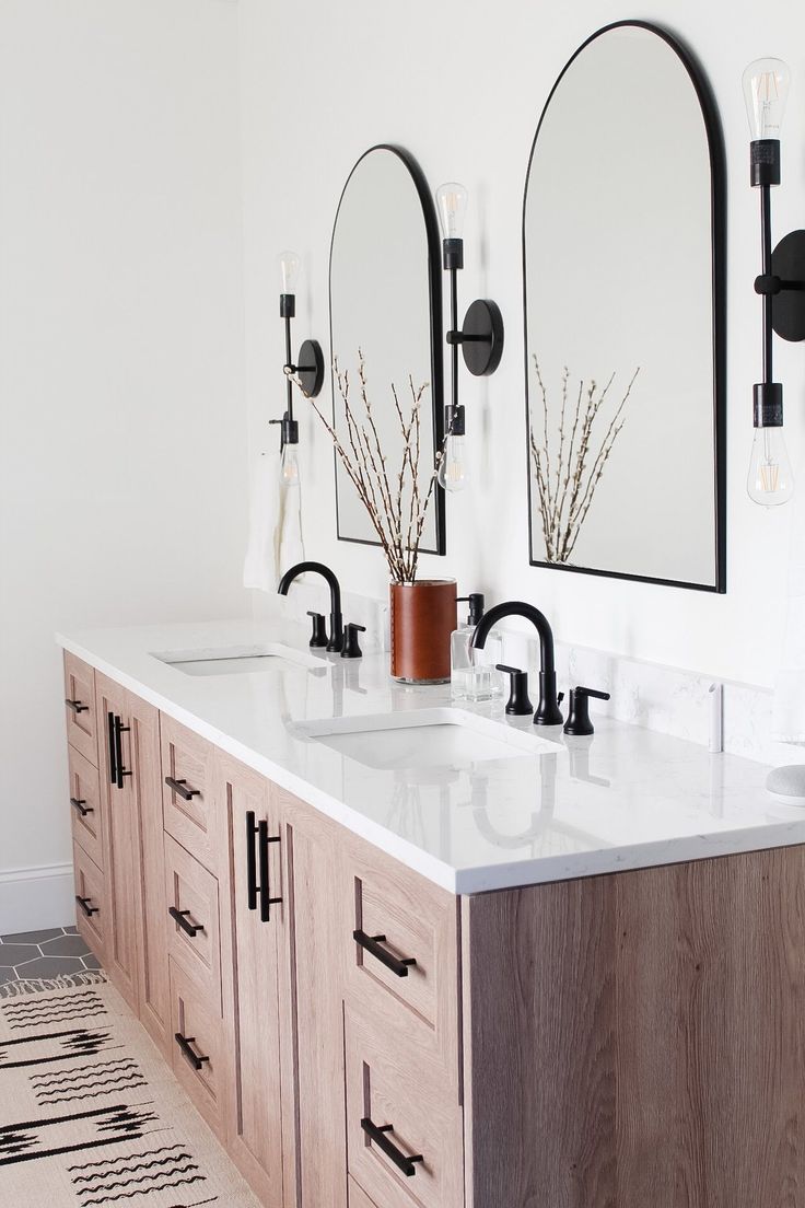 a bathroom with double sinks and mirrors on the wall