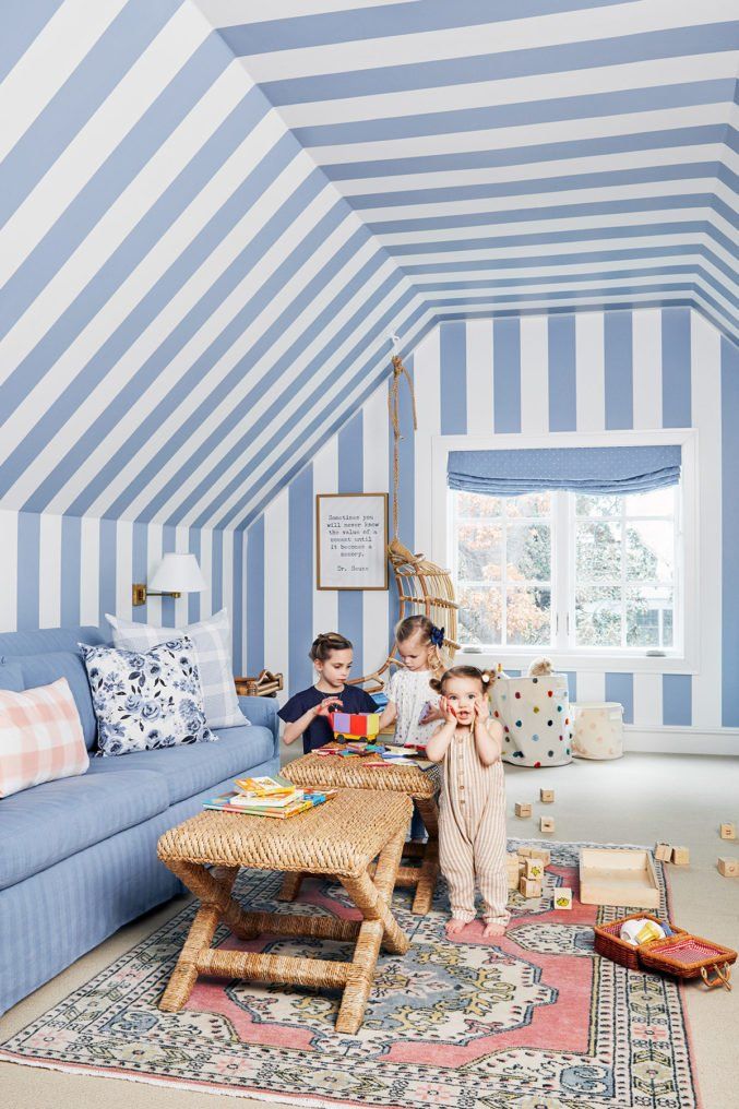 three children are playing in the blue and white striped room