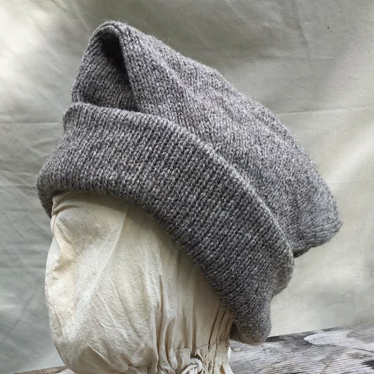 This Tubular knit hat is able to be worn a variety of ways. Can be doubled with a tapered flap hanging to one side of the head or folded completely in and turned up around the brim for 4 layers of warm wool around the ears. The pattern I have developed is based on a hat recovered from the "Machault" ship This medium we Knitting History, Knit Toque, Flap Hat, Disco Fashion, Knit Hat For Men, Wool Projects, Sport Weight Yarn, Handspun Yarn, Knit Cap