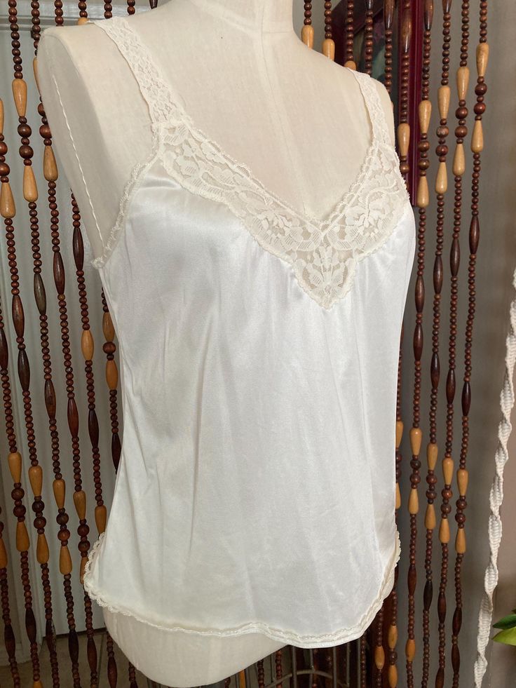 Sweet little cream colored camisole with stretchy lace straps. Brand is vanity fair, tag  says size 36/42, the dress form is an 8 and it is loose on it. Modern size large, or 10. it has some stretch. Lace V-neck Camisole, Cream Camisole With Built-in Bra And Spaghetti Straps, Sleeveless Lace Camisole For Wedding Night, Fitted Summer Camisole With Lace Back, Fitted Lace Back Camisole For Summer, Fitted Lace-back Camisole For Summer, Summer Camisole With Lace Bodice, Summer Lace Bodice Camisole, Feminine Fitted Lace Tank Top