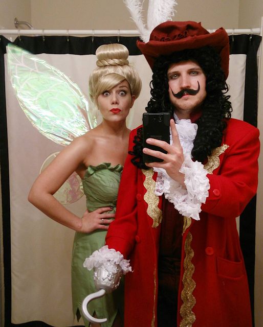 a man and woman dressed up as tinkerbells, one holding a cell phone