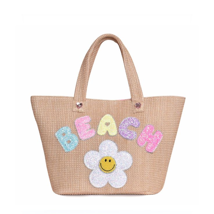 Front view of straw 'Beach' tote bag with glitter daisy and bubble-letter patches Beachy Sand-colored Beach Bag With Braided Handles, Spring Beach Sand-colored Straw Bag, Trendy Top Handle Beach Shoulder Bag, Trendy Crochet Top Handle Bag For Beach, Beach Season Bags With Braided Handles And Top Handle, Daily Use Summer Beach Bag With Top Handle, Summer Vacation Bags With Top Handle, Summer Vacation Bag With Top Handle, Top Handle Bag In Natural Color For Beach Season