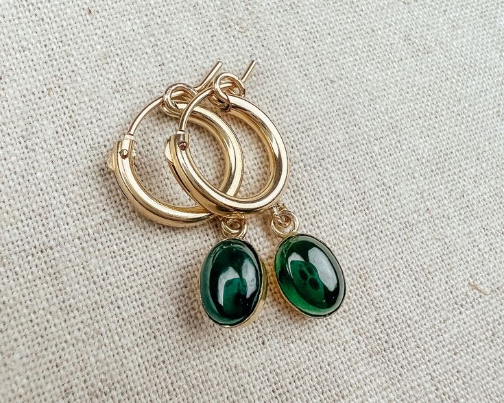 Simple gold filled huggie hoop earrings featuring beautiful green Jade oval stone. Adds a touch of sophisticated glam to your everyday look. Can easily pair with casual or formal looks. Details ----------------------------- Gemstone: Jade cabochon Material: 14k Gold Filled Size:      - Jade: 6 x 8 mm     - Hoop: 13mm *Note* Due to the nature of natural gemstones, there might be slight variations. You will not receive the exact piece in the pictures. Your earrings will be as unique as you! Elegant Hypoallergenic May Birthstone Hoop Earrings, Green Tarnish Resistant Hoop Earrings For Gift, Green 14k Gold Huggie Earrings Gift, Elegant Everyday Hoop Earrings With May Birthstone, Dainty Green Huggie Earrings As Gift, Green Tarnish Resistant Huggie Earrings For Gifts, Elegant Green 14k Gold Filled Hoop Earrings, Dainty Style, Jade Earrings