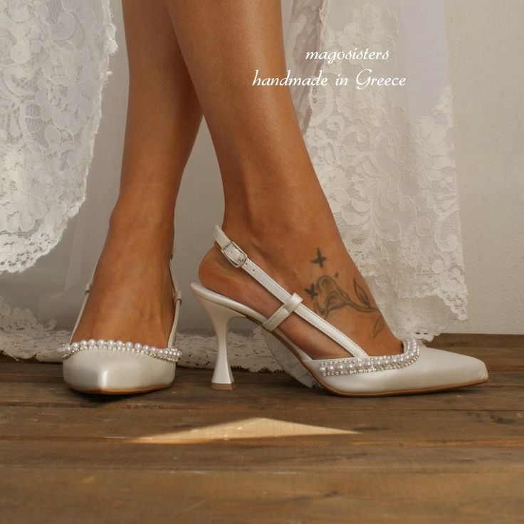 a woman's legs wearing white high heels with pearls on the toes and ankle