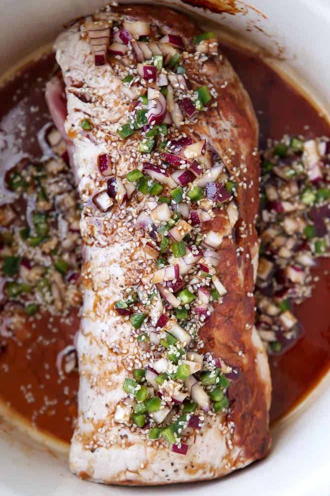 the fish is covered in sauce and garnished with green onions