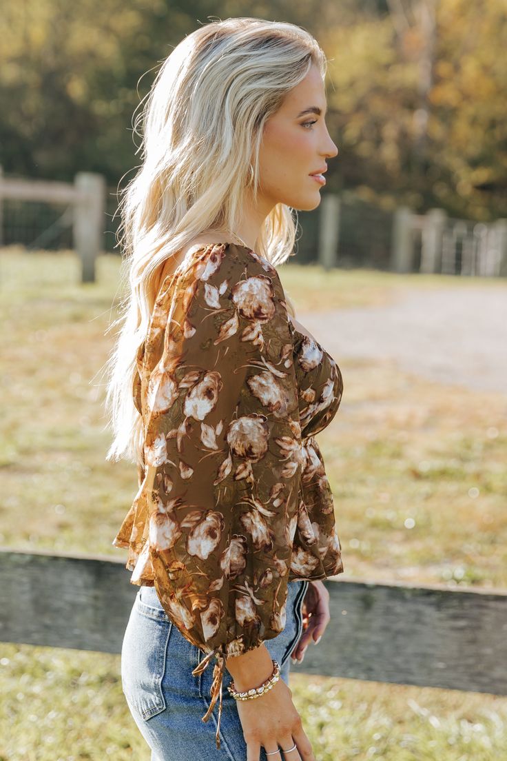 Embrace boho-chic vibes with the Olive Multi Floral Print Blouse, perfect for adding a touch of romance to any outfit! Features 3/4 sleeve length with delicate tie cuffs for a feminine flair. Designed with a square neckline and an elastic waistband for a flattering silhouette. The flowy hem creates a graceful movement, making it a versatile piece for day or night. Pair it with your favorite jeans or a skirt for an effortlessly stylish look. Brown Square Neck Top For Spring, Fall Brunch Blouse With 3/4 Sleeves, Flowy Brown Blouse For Fall, Chic Blouse With Floral Print And 3/4 Sleeves, Bell Sleeve Blouse For Day Out In Fall, Fall Brunch Blouse With Tie Sleeves, Bell Sleeve Blouse For Fall Day Out, Fall Bell Sleeve Blouse For Day Out, Flowy Bell Sleeve Blouse For Fall