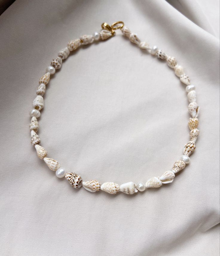 Shell beaded necklace Beaded Shell Bracelet, Beaded Necklace With Shell, Beaded Necklace Beach, White Shell Necklace As Gift, Pearl Shell Necklace For Vacation, Vacation Pearl Shell Necklace, Bohemian Single Strand Pearl Necklace For Beach, Pearl Strand Beaded Necklaces For Beach, Mother Of Pearl Strand Necklace For Gift