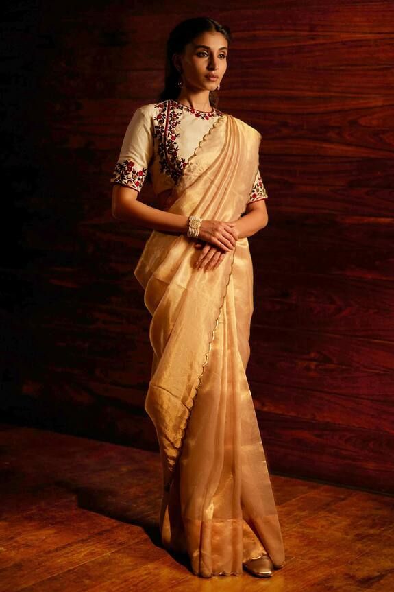 Gold silk tissue woven saree with metallic sequin embroidered scalloped borders. Comes with unstitched blouse piece.
Components: 2
Pattern: Woven and Embroidered 
Type Of Work: Sequin Work
Fabric: Silk Tissue
Color: Gold
Other Details: 
Note: The stitched blouse worn by the model is not for sale
Occasion: Wedding,Reception - Aza Fashions Luxury Traditional Wear In Tissue Silk With Weaving Work, Gold Tussar Silk Pre-draped Saree For Reception, Gold Cotton Silk Pre-draped Saree For Reception, Festive Cotton Silk Pre-draped Saree For Celebration, Bollywood Style Pre-draped Cotton Silk Saree For Reception, Festive Embroidered Slub Silk Pre-draped Saree, Bollywood Style Raw Silk Blouse With Sheer Dupatta, Bollywood Style Slub Silk Blouse With Sheer Dupatta, Traditional Slub Silk Pre-draped Saree For Celebration